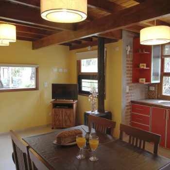 Cabaña Amanecer - amplia cocina comedor y living con vista al bosque, mar azul, spa del puente